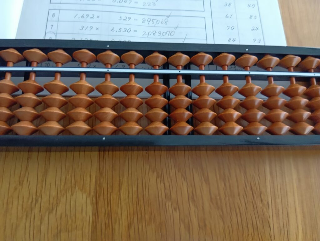 木のテーブルの上に置いたそろばんとドリル